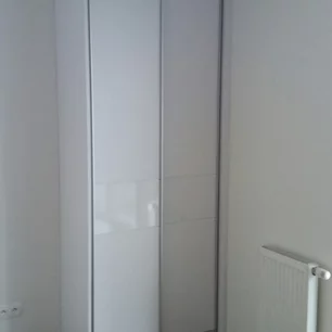 úzka vstavaná skriňa s bielymi posuvnými dverami